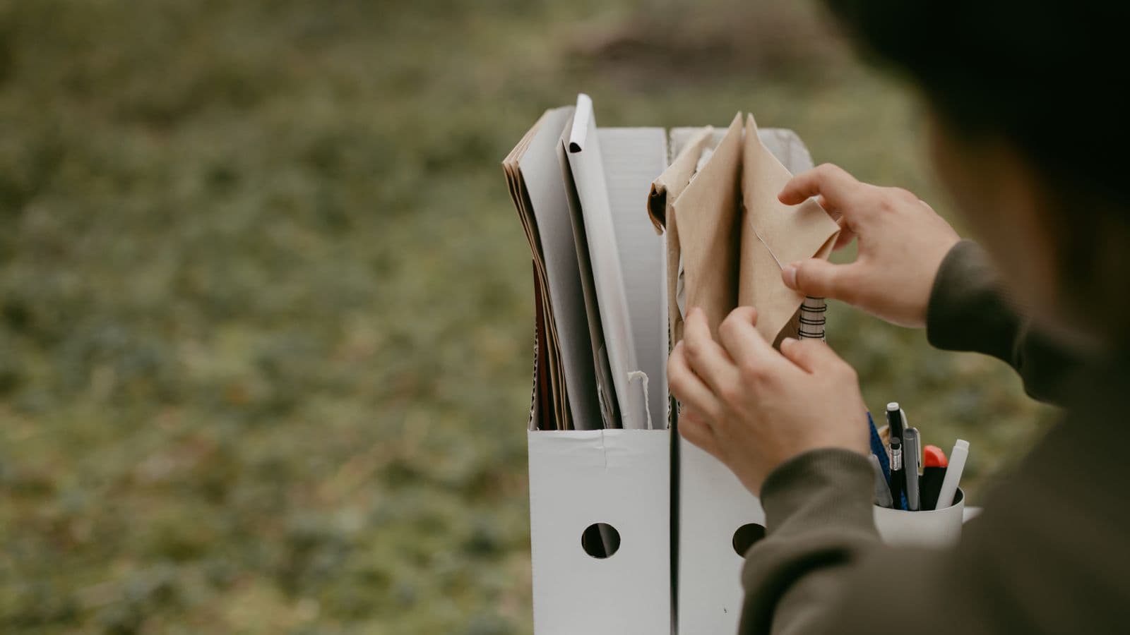 A person sorting documents into folders, representing IRS accountable plan documentation rules