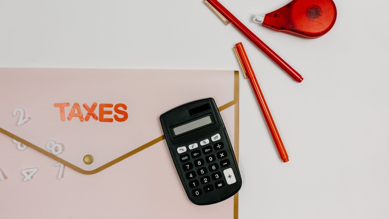 Tax forms and a calculator on a desk, representing when per diem payments become taxable income
