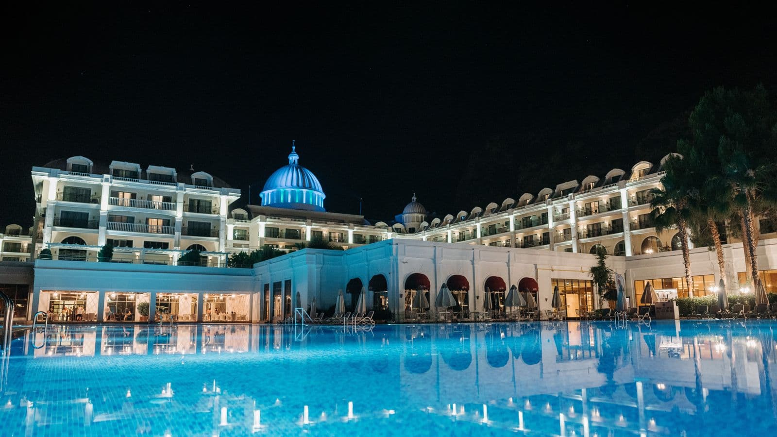 A resort hotel exterior with a pool, representing how GSA lodging per diem rates change by season in peak travel cities