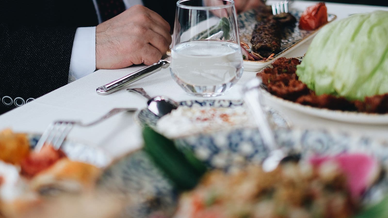 A business lunch at a restaurant table, representing the meals portion of a GSA M&IE per diem rate