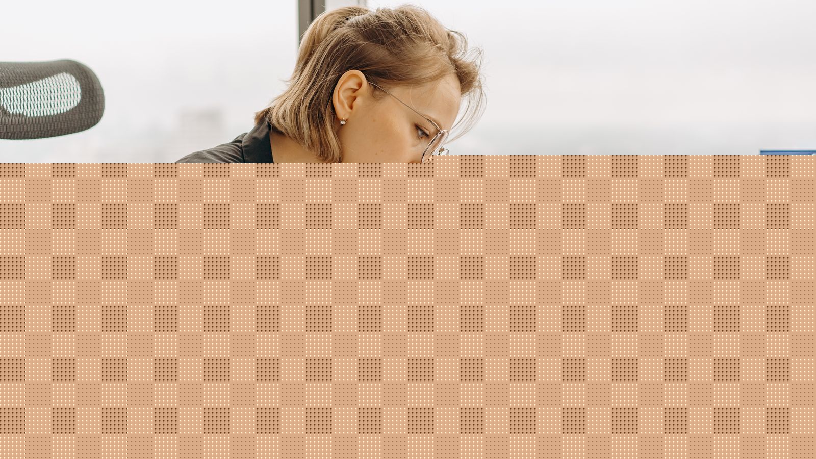 Woman accountant calculating financial documents at office desk, representing employer mileage reimbursement policy for 2026