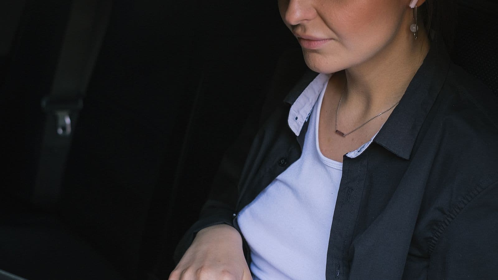 A person using a laptop inside a parked car, representing the mileage tax deduction for the self-employed