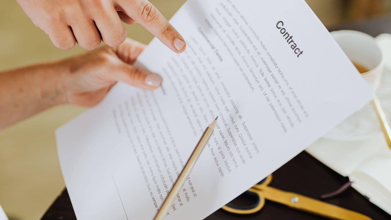 Hands reviewing a contract next to a laptop, representing per diem employee rights and entitlements