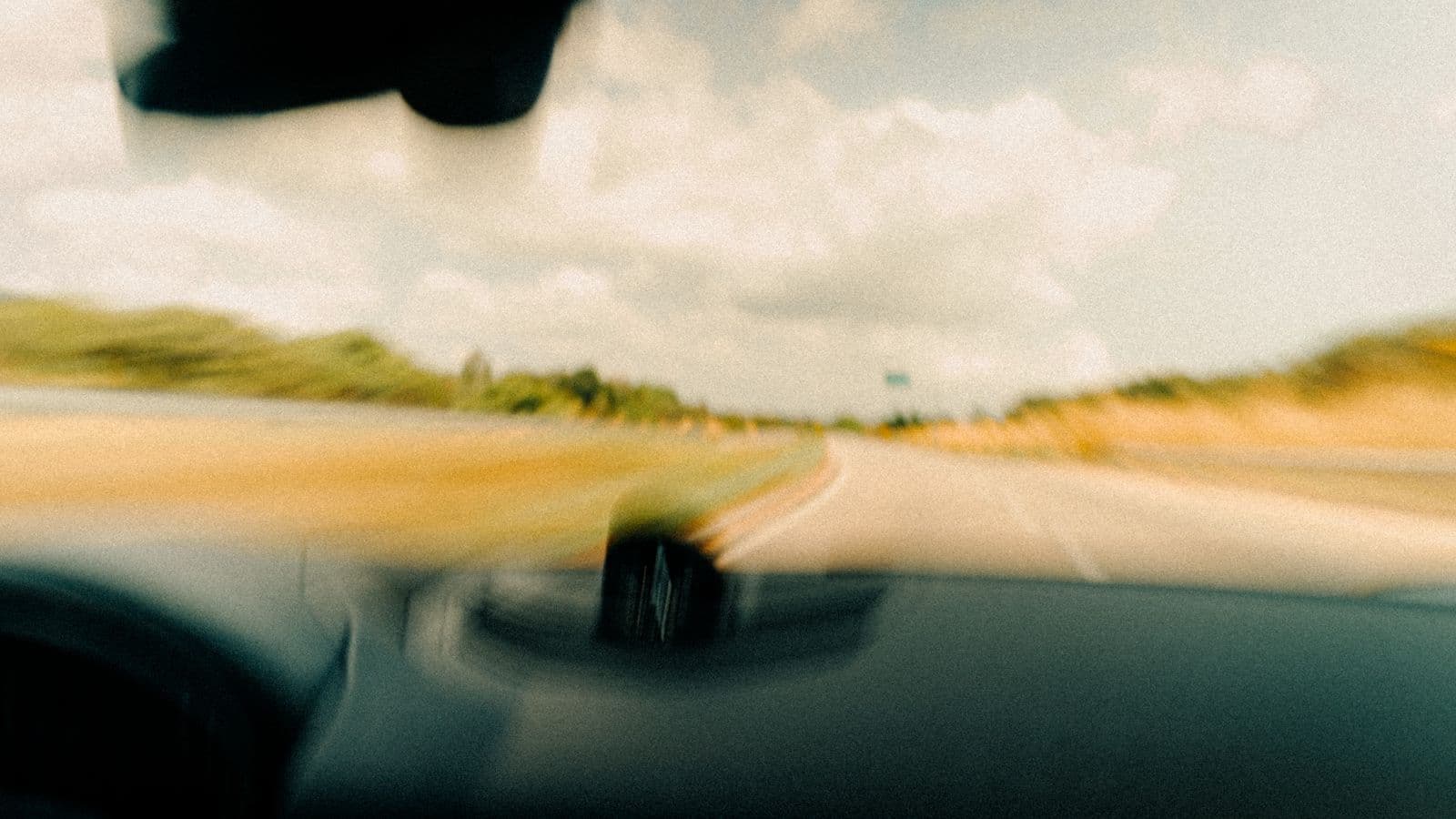 A car on a highway during a road trip, representing a combined driving and overnight business trip
