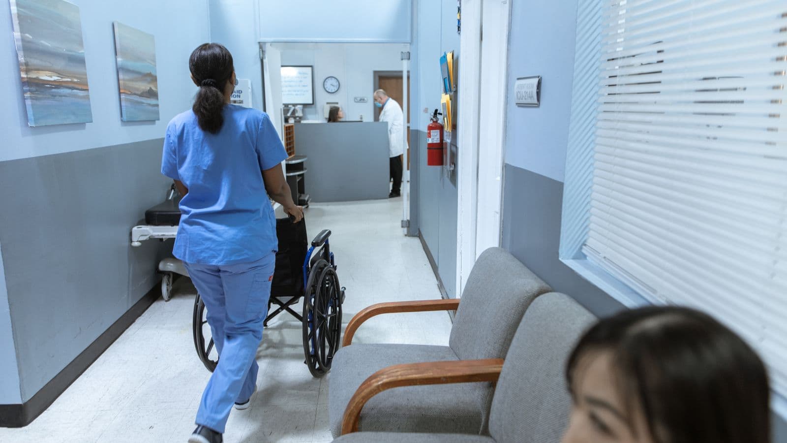 A travel nurse in scrubs walking through a hospital corridor, representing per diem and stipend pay for travel nursing assignments