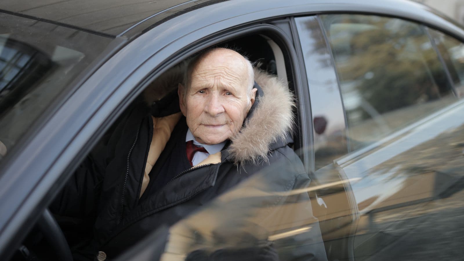A veteran driving a car, representing VA beneficiary travel mileage reimbursement to medical appointments