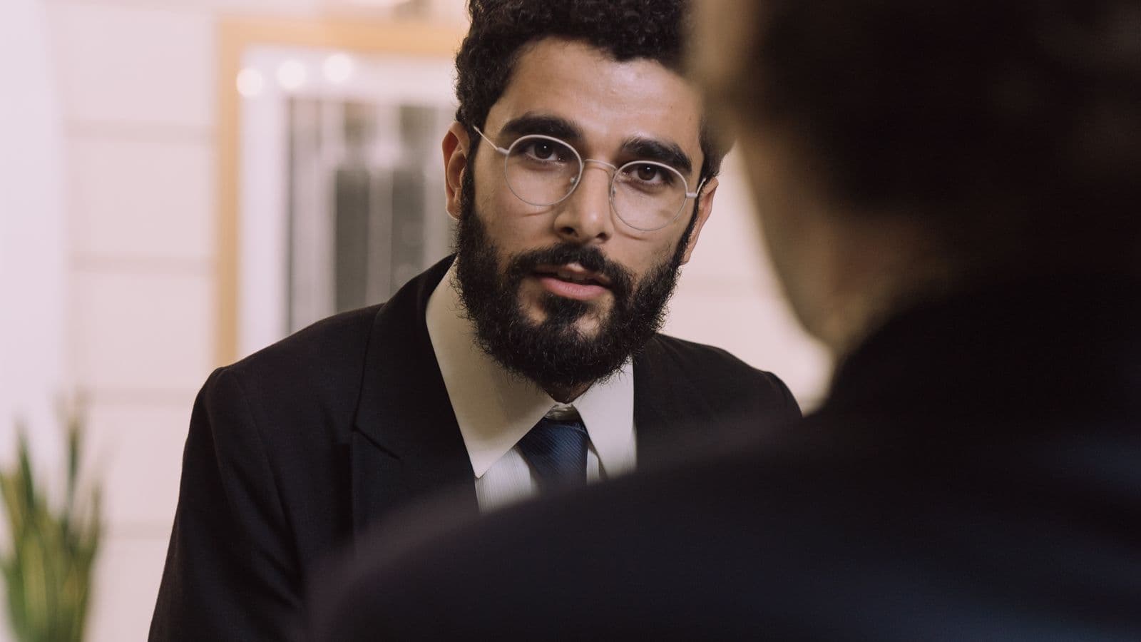 A business traveller checking in at a hotel reception desk, representing a per diem daily travel allowance